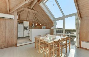 eine Küche mit Tisch und Stühlen und einem großen Fenster in der Unterkunft Amazing Home In Hvide Sande With Wifi in Havrvig