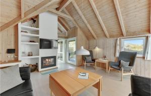 ein Wohnzimmer mit Tisch und Kamin in der Unterkunft Amazing Home In Hvide Sande With Wifi in Havrvig