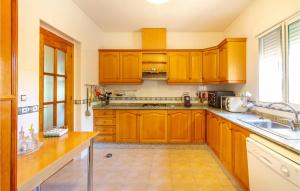 a kitchen with wooden cabinets and a sink at Beautiful Home In Pliego in Pliego