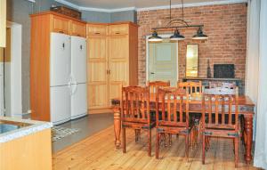 a kitchen with a wooden table with chairs and a refrigerator at Stunning Home In Värmlands Nysäter in Varmlands Nysater