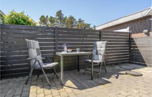 two chairs and a table in front of a fence at Holiday Home Bl in Blåvand +16 photos