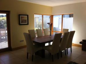 a dining room with a wooden table and chairs at Bearlough Self Catering Holiday Home in Rosslare