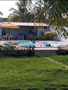 een persoon die in een zwembad in een tuin ligt bij Sítio esperança in Camassari