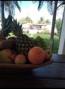 een fruitschaal op een houten tafel bij Sítio esperança in Camassari