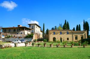 un cortile con una casa sullo sfondo con un prato di Armonie di Villa Incontri B&B a Firenze