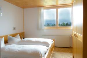 a bedroom with a bed and a window at Ferienbauernhof Roth in Sulzberg