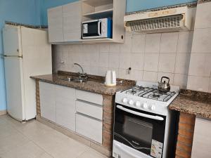 een keuken met een fornuis en een spoelbak bij La Loma in Salta