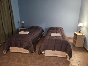 twee bedden in een kamer met twee lampen op tafels bij La Loma in Salta