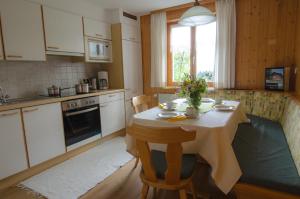 a kitchen with a table with flowers on it at Ferienbauernhof Roth in Sulzberg