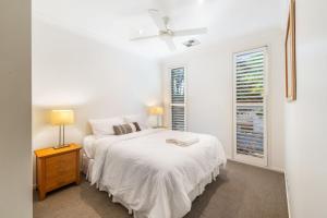 ムールーラバにある4 bedroom waterfront dream holiday home and small pet friendlyのベッドと窓のある白い寝室 +14枚の写真