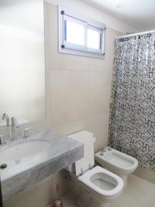 a bathroom with a sink and a toilet and a window at Studio en Ovidio Lagos in Rosario