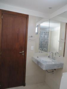 a bathroom with a sink and a wooden door at Studio en Ovidio Lagos in Rosario