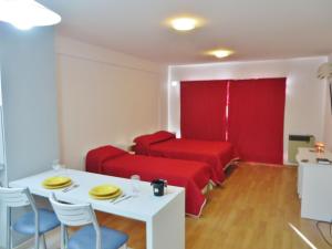 a living room with a red couch and a table and chairs at Studio en Ovidio Lagos in Rosario