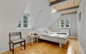 una camera da letto bianca con un letto e una sedia di 6 Bedroom Cozy Home In Dannemare a Dannemare Altre 21 foto