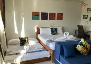 a bedroom with two beds and a blue couch at Affordable Group Stay with a Balcony, Free Parking, Pool and Gym - B2 7Opals in Puerto Princesa City +123 photos