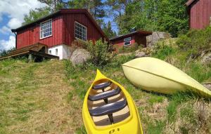 un kayak giallo e una tavola da surf di fronte a una casa di Cozy Home In Kvinesdal With Sauna a Kvinesdal