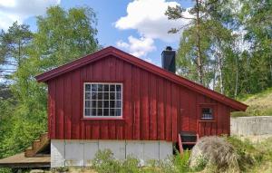 un fienile rosso con una finestra e delle scale su una collina di Cozy Home In Kvinesdal With Sauna a Kvinesdal