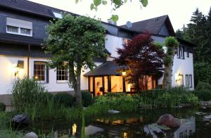 a house with a pond in front of it at Hotel Zum Hackstück in Hattingen