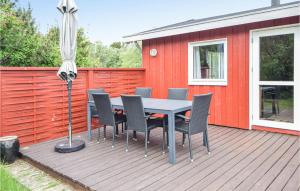 a table and chairs on a deck with an umbrella at Alsbo in Sønderho +17 photos
