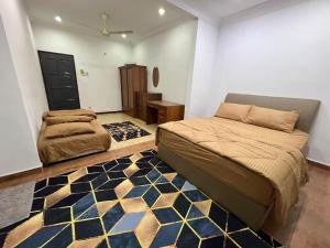 a bedroom with two beds and a rug at Odel Guest House in Kampong Sungai Buah