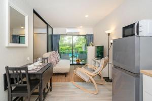 a kitchen and living room with a table and a refrigerator at The Title Residencies Nai Yang - 1 Bedroom Apartment in Nai Yang Beach