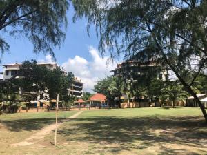 a park with trees and buildings in the background at Samsuria Beach Apartment Resort in Kuantan