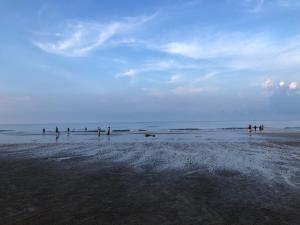 a group of people standing on a beach at Samsuria Beach Apartment Resort in Kuantan