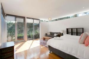 Un dormitorio con una cama grande y una sala de estar. en Oceania Retreat - Private beach access pool OFP, en Rye 17 fotos más