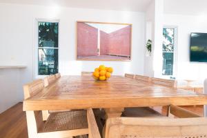 a wooden table with a bowl of oranges on it at Tallows House on Paterson in Byron Bay +63 photos