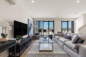 ein Wohnzimmer mit Sofa und Fernseher in der Unterkunft Castaway Villa - Luxe on the Marina Walk to Beach in Safety Beach