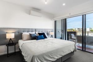ein Schlafzimmer mit einem großen Bett und einem großen Fenster in der Unterkunft Castaway Villa - Luxe on the Marina Walk to Beach in Safety Beach