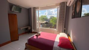a bedroom with a bed and a large window at Hostal Casa Blanca in El Coca