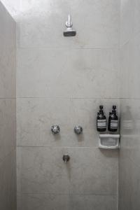 a bathroom with a shower with two bottles of alcohol at Hotel María de la Luz in Valladolid +118 photos