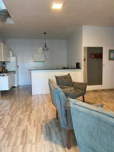 a living room with two couches and a kitchen at Pousada QUERÊNCIA FRANCÊS in Marechal Deodoro