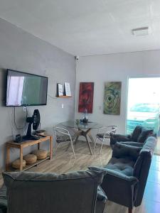 a living room with a tv and a table and chairs at Pousada QUERÊNCIA FRANCÊS in Marechal Deodoro +15 photos