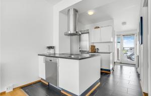una cucina con mobili bianchi e un piano di lavoro nero di Apartment Nordre Havnevej Rømø V a Rømø Kirkeby