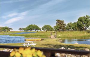 a picnic table next to a lake with two boats at Amazing Home In Fågelmara With Wifi in Fågelmara
