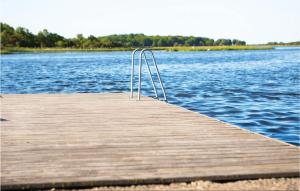 a wooden dock with a metal railing on the water at Amazing Home In Fågelmara With Wifi in Fågelmara
