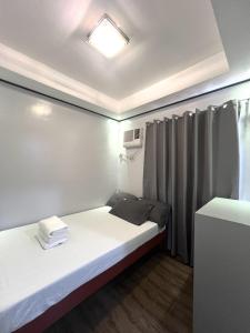 a small room with a bed and a window at Lady L Apartelle Boracay in Boracay