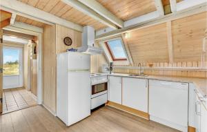 a kitchen with white appliances and a wooden ceiling at Holiday Home Hvide Sande With A Fireplace 05 in Bjerregård