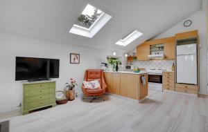 a kitchen with a tv and a chair in a room at Cozy Home In Glesborg With Wifi in Glesborg