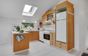 a kitchen with a white refrigerator and wooden cabinets at Cozy Home In Glesborg With Wifi in Glesborg