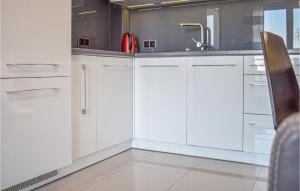 a kitchen with white cabinets and a sink at Nice Apartment In Darlowko With Wifi in Darłówko
