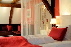 a bedroom with a bed with red pillows at Altes Amtshaus, 3-Sterne Hotel Garni Superior in Mulfingen-Ailringen