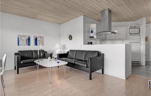 a living room with two leather chairs and a table at Holiday Home Romo 22 With Hot Tub in Rømø Kirkeby