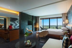 a hotel room with a bed and a living room at Renaissance Bali Uluwatu Resort & Spa in Uluwatu