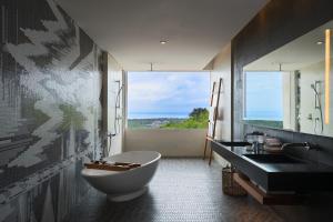 a bathroom with a tub and a sink and a window at Renaissance Bali Uluwatu Resort & Spa in Uluwatu