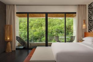 a bedroom with a bed and a large window at Renaissance Bali Uluwatu Resort & Spa in Uluwatu