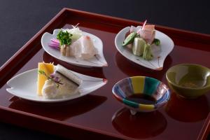 three plates of food on a red tray at Charoku Bekkan in Miyazu