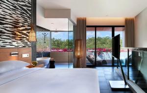 a hotel room with a bed and a tub and a bathroom at Renaissance Bali Uluwatu Resort & Spa in Uluwatu
